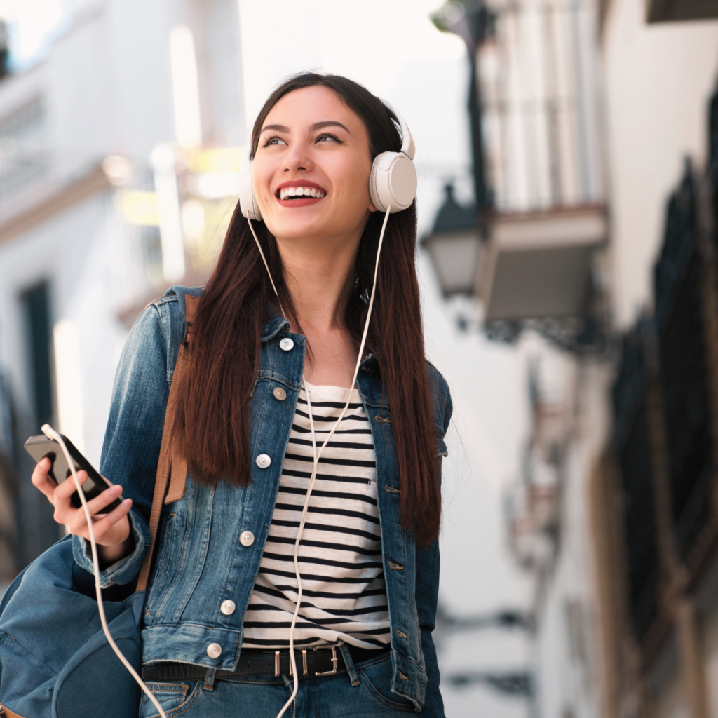 Mujer sonriendo mientras disfruta de un audio tour con HearGo