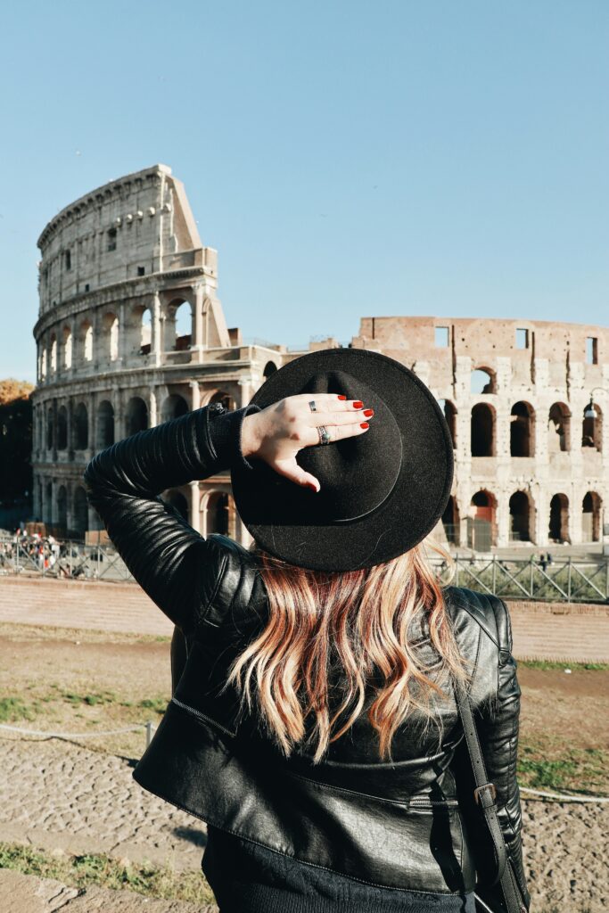 Mujer disfrutando de un audio tour mientras visita el Coliseo con la app HearGo